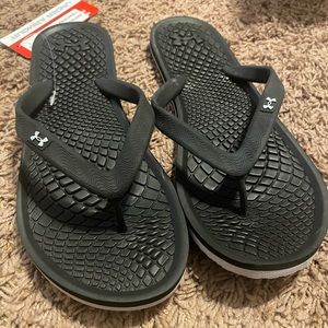 Women’s. Never wore. NWT. Black Under Armour flip flops.